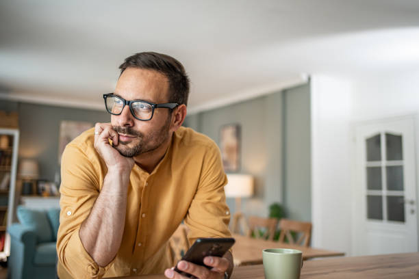 istock Portrait of cheerful man using smartphone at home 1817450208