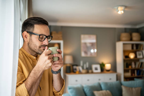 istock Smiling happy man drinking a cup of coffee at home 1817453592