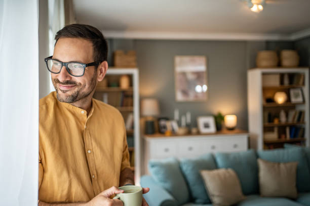 istock Smiling happy man drinking a cup of coffee at home 1817453594