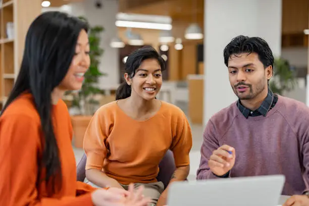 In this modern office, where laptops outnumber coffee cups, a squad of diverse go-getters navigates the meeting like seasoned meme creator