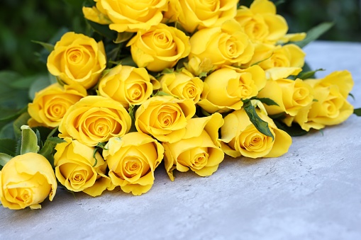 Beautiful bouquet of yellow roses on light table, closeup