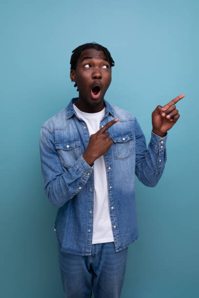 istock charismatic stylish african man with black dreadlocks points finger to the side 1817463301