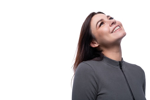 Portrait of young joyful cheerful brunette woman on studio white background.