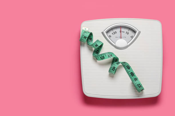 istock Bathroom scale and measure tape on pink background, top view. Space for text 1817473570