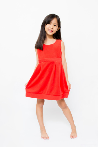 Smiling little Asian child in fashion red dress