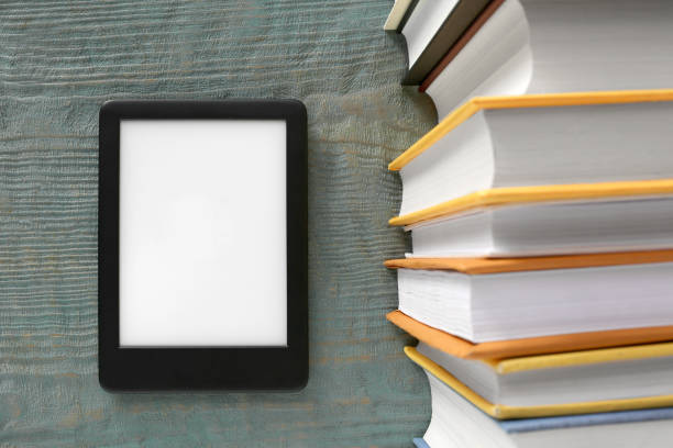 istock Portable e-book reader and hardcover books on wooden rustic table, flat lay 1817498007