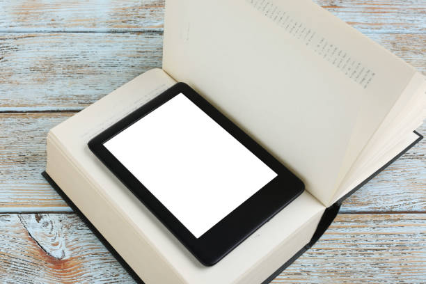 istock Portable e-book reader and hardcover book on wooden rustic table 1817498022