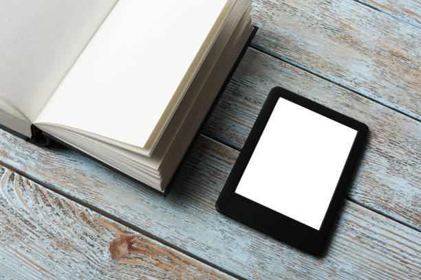 istock Portable e-book reader and hardcover book on wooden rustic table 1817498526