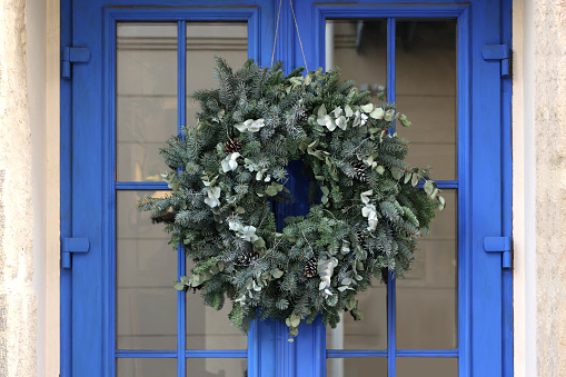 Beautiful Christmas wreath hanging on blue glass door