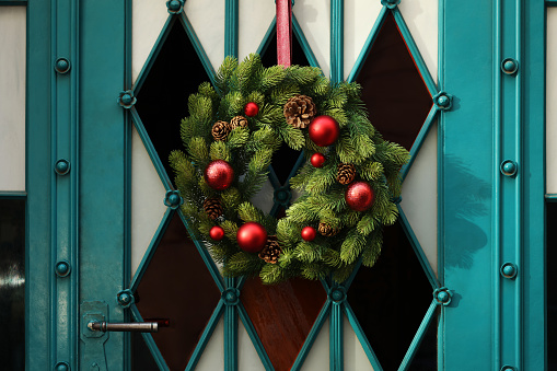 Beautiful Christmas wreath hanging on turquoise door