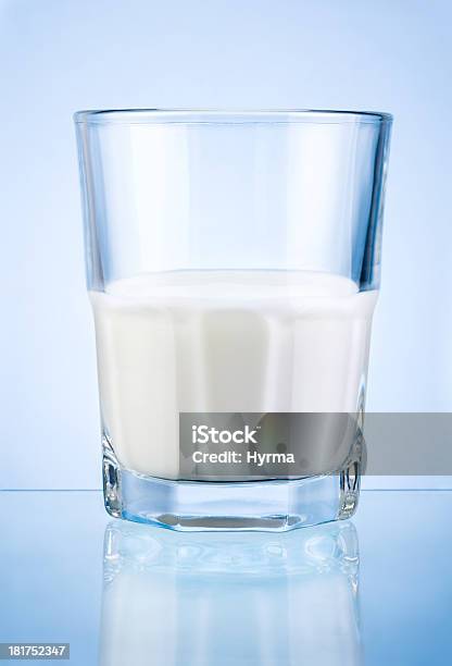 Photo libre de droit de Un Demiverre De Lait Isolé Sur Fond Bleu banque d'images et plus d'images libres de droit de Lait - Lait, Moitié plein, Verre