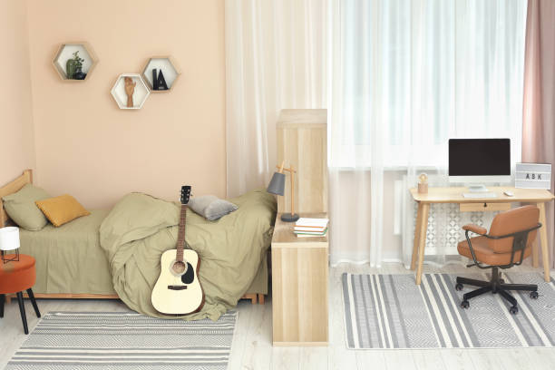 istock Stylish teenager's room interior with comfortable bed and workplace 1817525060