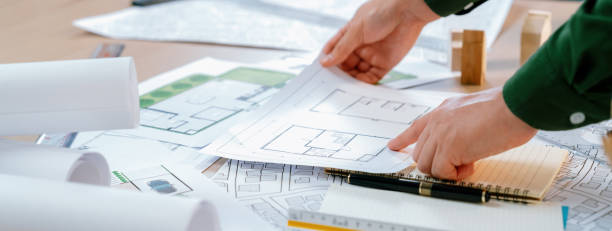 istock Experienced architect chooses the blueprint on messy table. Delineation. 1817601748