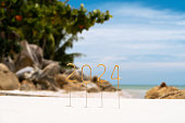 Numbers 2024 for the New Year on a tropical beach with a snow-white squeak, celebrating in a tropical country