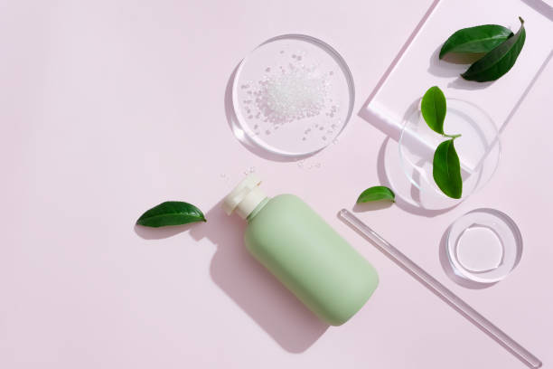 istock An unlabeled pastel cosmetic bottle is displayed against a minimalist background with some glass props and fresh green tea leaves. Creative space for cosmetic advertising. 1817721569