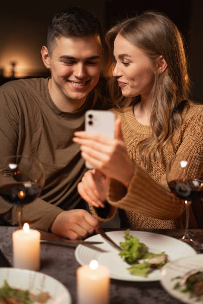 istock Happy young couple using smartphone browsing internet during romantic date dinner at home. 1817748594