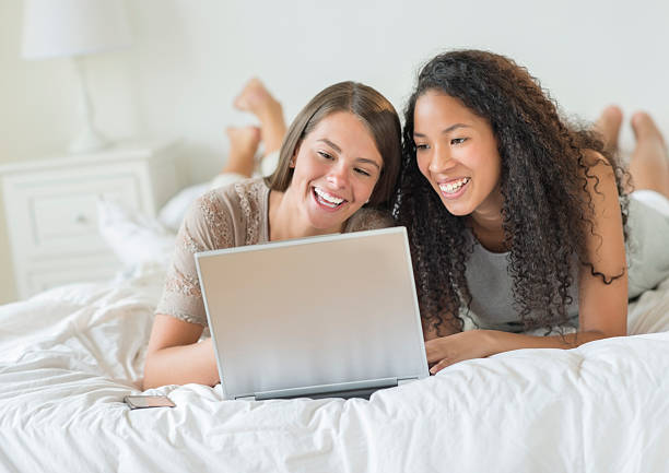 istock Happy Female Friends Using Laptop In Bed 181775882