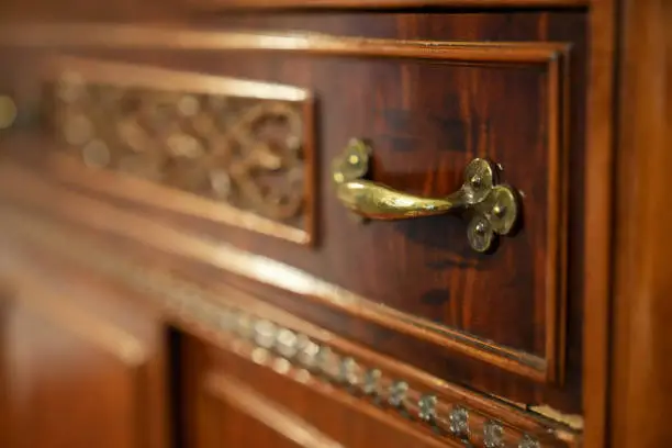 Photo of Close up detail of antique brass drawer handle