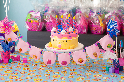 Birthday cake on a table with presents in the background