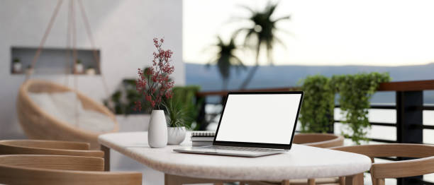 istock A white-screen laptop computer on a table on a beautiful home balcony. Home workspace, closeup image 1817815437