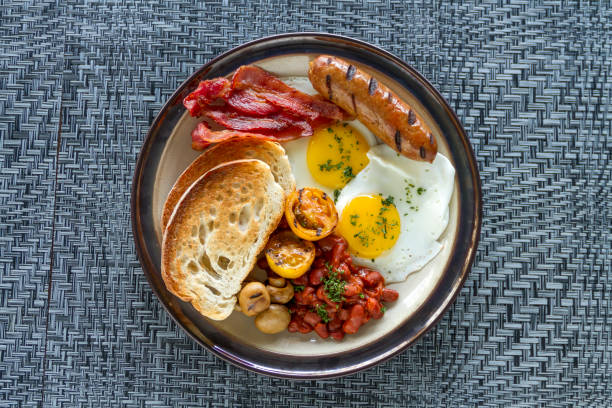 istock A breakfast plate featuring sausage, bacon, toasted bread, fried egg, and grilled vegetables 1817821948