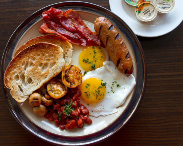 istock A breakfast plate featuring sausage, bacon, toasted bread, fried egg, and grilled vegetables 1817827254