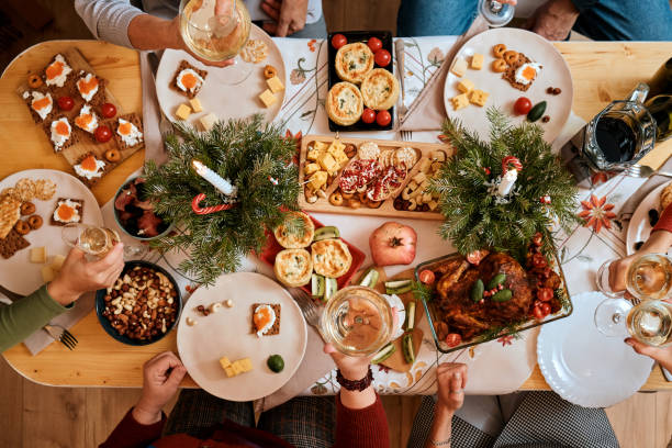 celebrating Christmas with the family New Year's Eve party, the big family dinner top view of a Christmas New Year's Eve decorated table, five non-personalized people eating at the table big family table stock pictures, royalty-free photos & images