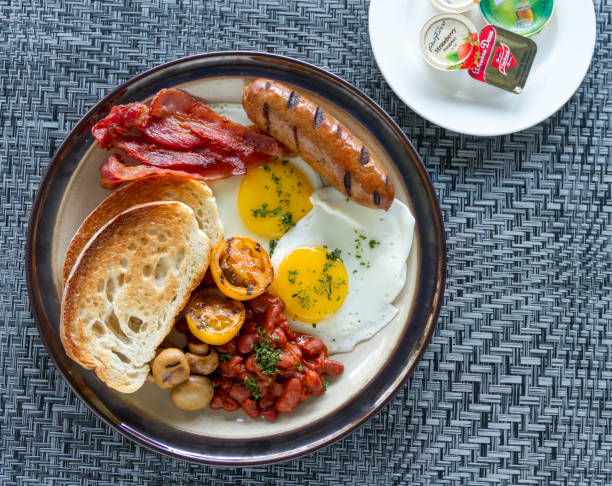 istock A breakfast plate featuring sausage, bacon, toasted bread, fried egg, and grilled vegetables 1817839947