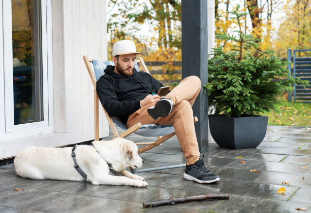 istock Young man sitting with dog on terrace 1817852786