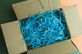 Blue shredded paper as straw and strands in brown box