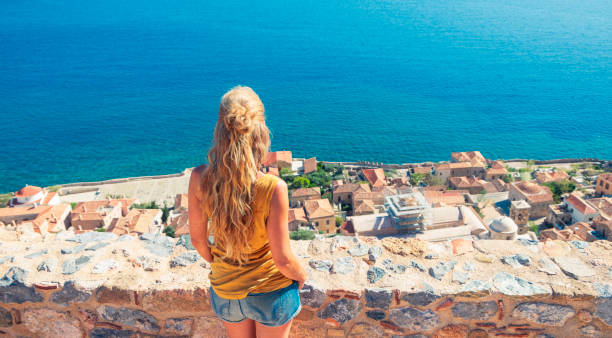 Woman looking at panoramic view of Monemvasia town panoramic view- Travel, tour tourism in Greece, Peloponnese Woman looking at panoramic view of Monemvasia town panoramic view- Travel, tour tourism in Greece, Peloponnese monemvasia stock pictures, royalty-free photos & images