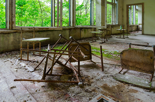 Broken chairs in empty premises of abandoned school in resettled village of Pogonnoye in Chernobyl exclusion zone, Belarus