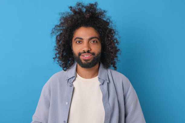 istock Young happy curly Arabian man with smile looking at camera stands in studio 1817939686