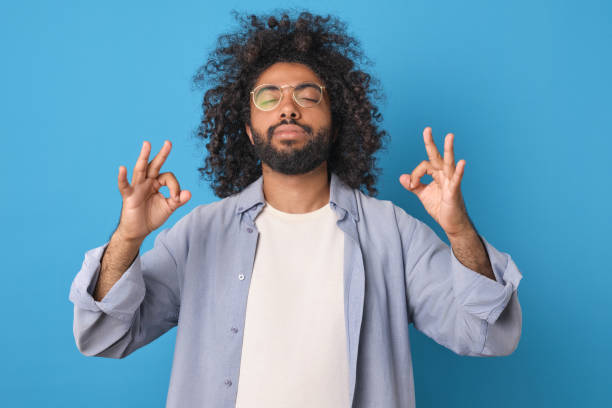 istock Young peaceful calm Indian buddhist man standing meditates in studio 1817944454
