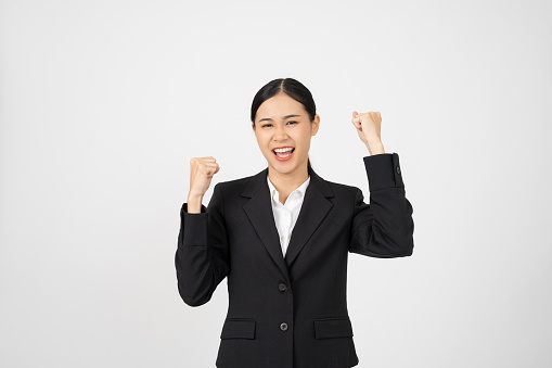 Happy businesswoman in black outfit with white isolated background. Celebrating pose.