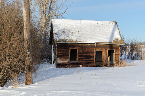 An abandoned house in the midst of a winter landscape