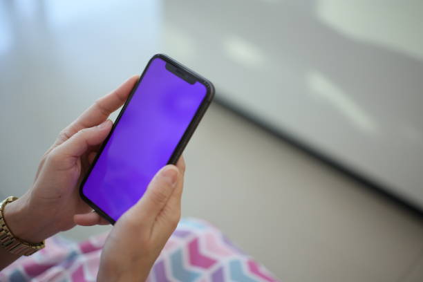 istock Hand holding phone purple screen in house 1817980713