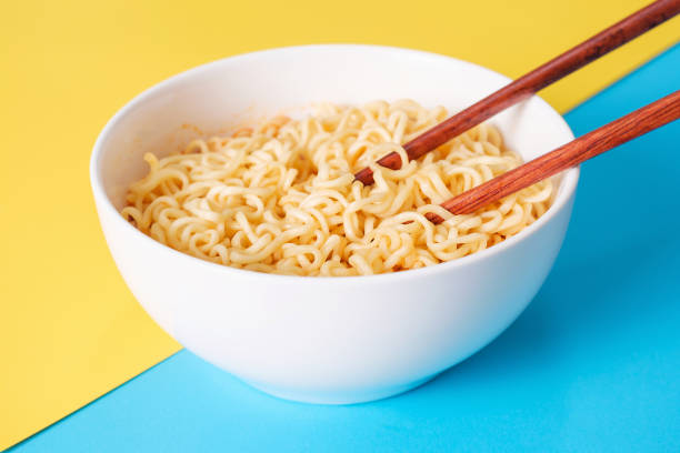 istock Bowl with korean ramen and chopsticks on yellow and blue background, front view. 1817982341