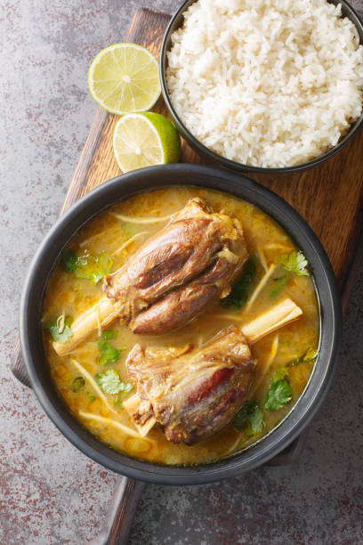Nihari is a rich slow-cooked meat stew flavored with spices and thickened with atta closeup on the wooden board. Vertical top view