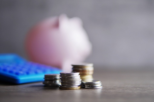 Selective focus image of coins, calculator and piggy bank with copy space for text. Financial concept.