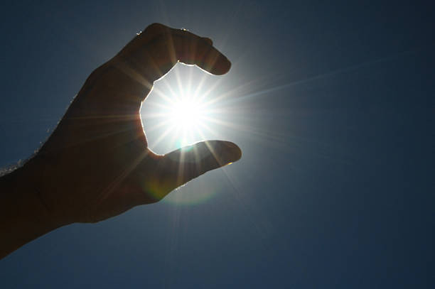 istock One Hand Catching the Sun Stars on a Blue Background 181802541