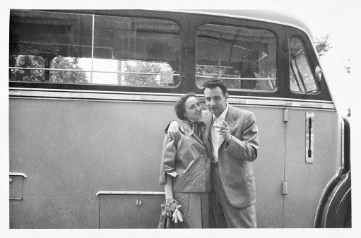 Young couple on a road close to a bus in 1955.