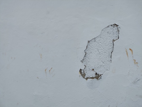 old white wall with a fairly large hole.