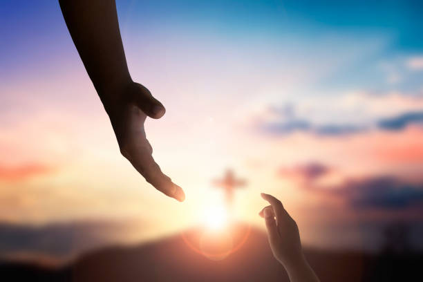 istock God's helping hand and cross on sunset background 1818049566