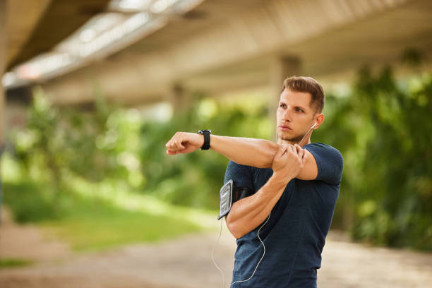 istock Young man stretching hand under bridge before workout outdoors 1818056462