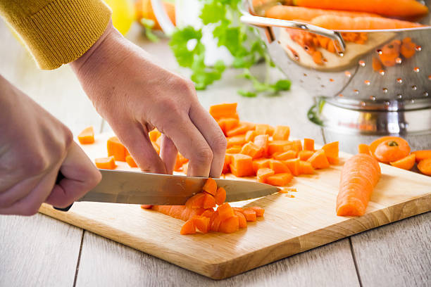 istock Woman chopping carrots with knife on board 181805662