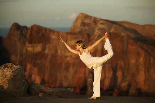 Athletic woman exercising Yoga balance on a mountain. Copy space.