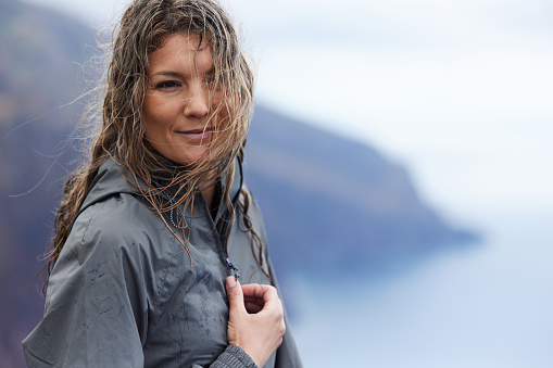 Portrait of carefree woman with wet hair during bad weather. Copy space.