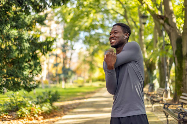 istock Handsome young man standing alone and stretching during his outdoor workout 1818077794