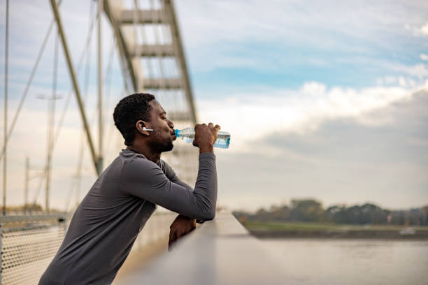 istock Sporty young man drinking water while out for a run 1818083877